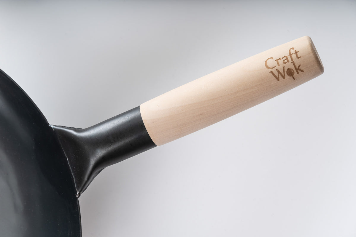 Traditionele, met de hand gehamerde koolstofstalen wok met houten en stalen handvat Traditionele, met de hand gehamerde koolstofstalen wok met houten en stalen handvat